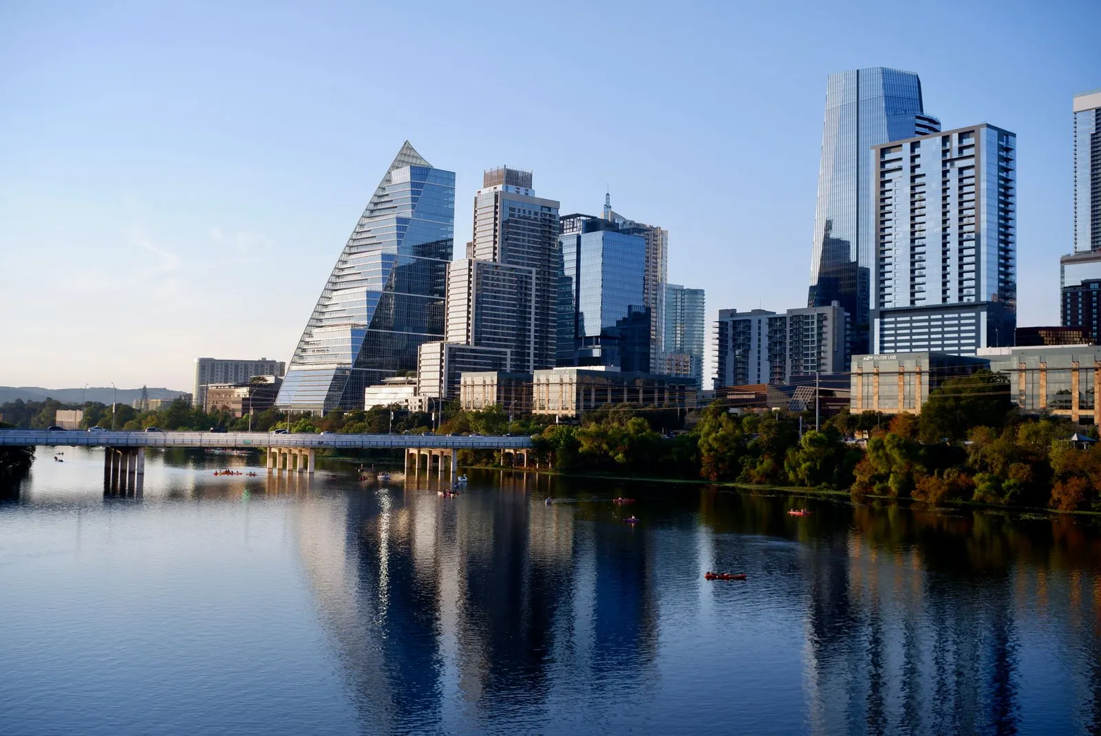 Austin: Stunning view of Austin's modern skyline reflecting on Lady Bird Lake during daylight.