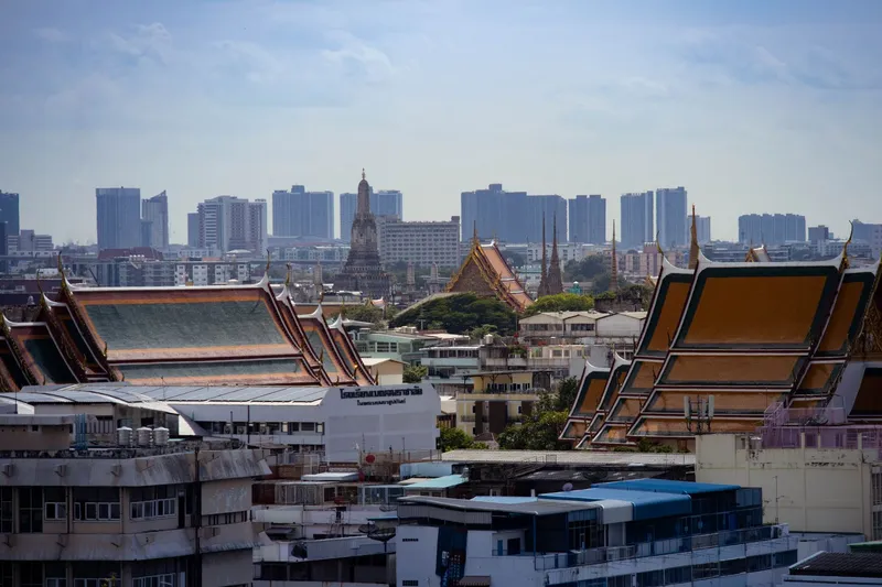 Bangkok: Skyline view of Bangkok highlighting traditional Thai architecture amidst modern buildings.