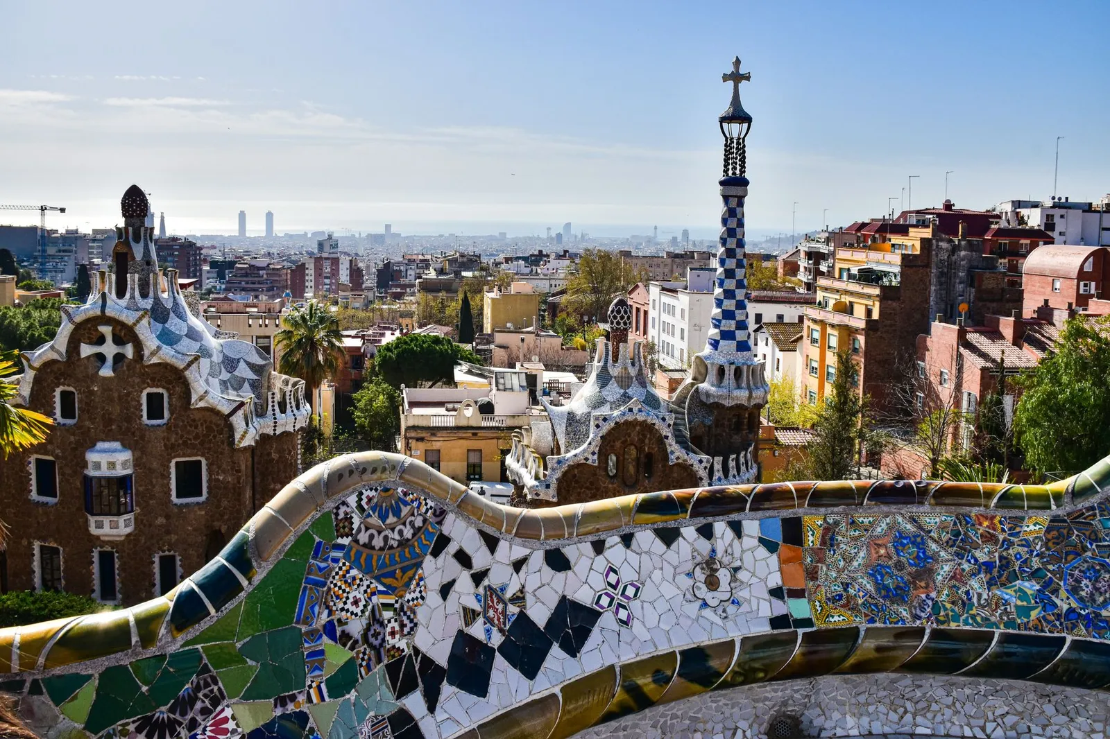 Barcelona: Gaudí's iconic mosaic architecture in Park Güell with a view of Barcelona's cityscape.