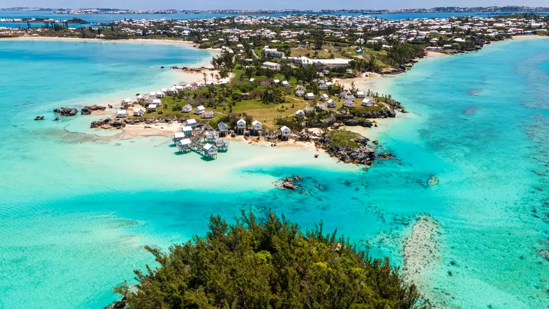 A stunning aerial shot capturing Bermuda's coastline with vibrant turquoise waters and charming houses.