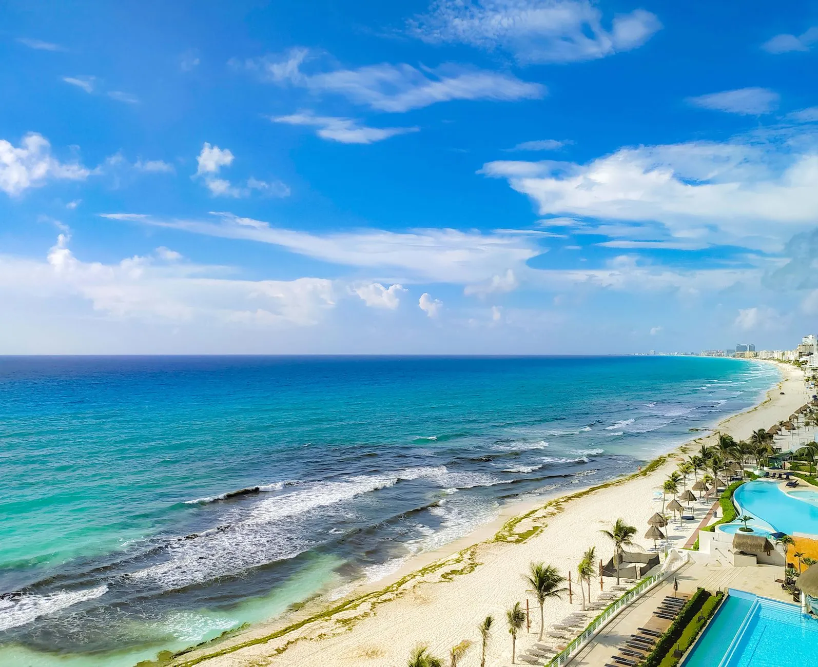Cancún: Aerial view of Cancún's coastline with turquoise sea, sandy beaches, and clear skies.