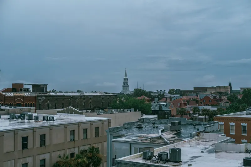 Charleston: Aerial cityscape of Charleston, SC showcasing historic architecture under a cloudy sky.