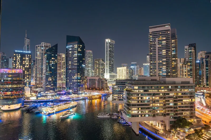Dubai: Stunning night view of Dubai Marina with illuminated skyscrapers and reflections on the water.
