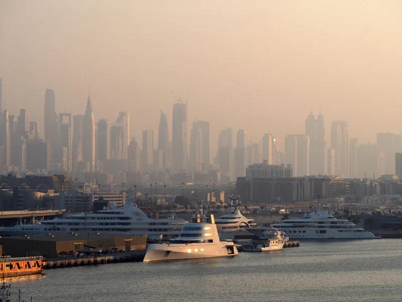 Dubai: Dubai Marina with luxury yachts against a skyline of iconic skyscrapers in the morning light.