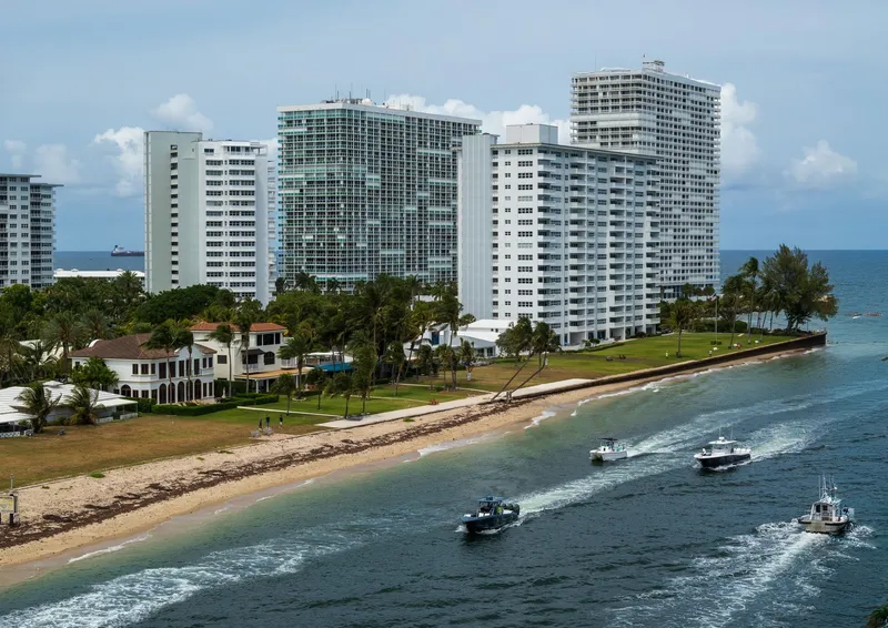 Fort Lauderdale: Aerial view of Fort Lauderdale high-rise buildings along the beach with boats on the water, exemplifying coastal city life.