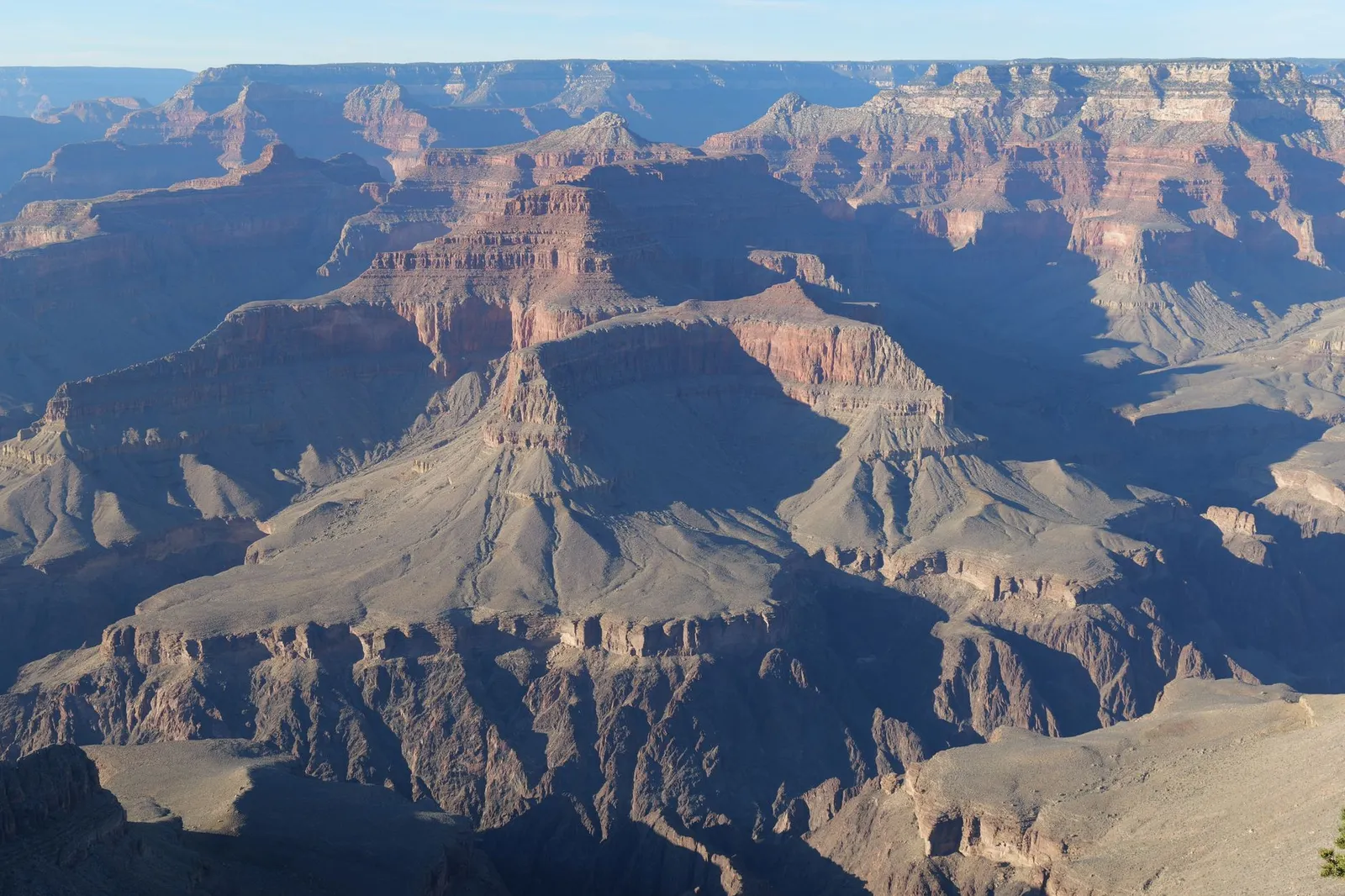 Grand Canyon: A stunning aerial view of the Grand Canyon showcasing its majestic cliffs, layers, and sunlight.