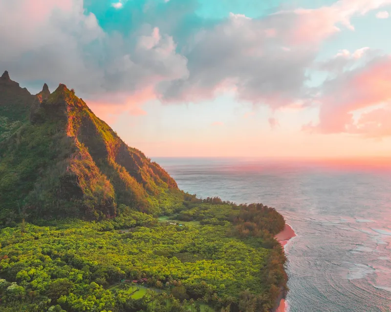 Kauai: Breathtaking view of Kauai's lush greenery and ocean at sunset, with vibrant colors and dramatic landscapes.