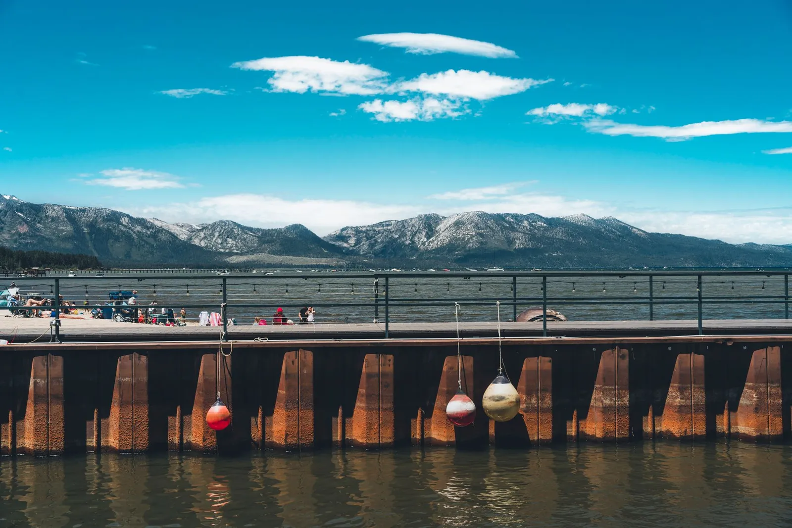 Lake Tahoe: Enjoy a sunny day at Lake Tahoe with mountains and a bustling boardwalk.