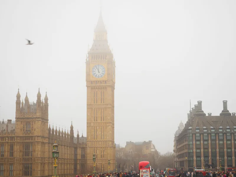 London: Iconic Big Ben tower enveloped in fog with bustling London street scene.