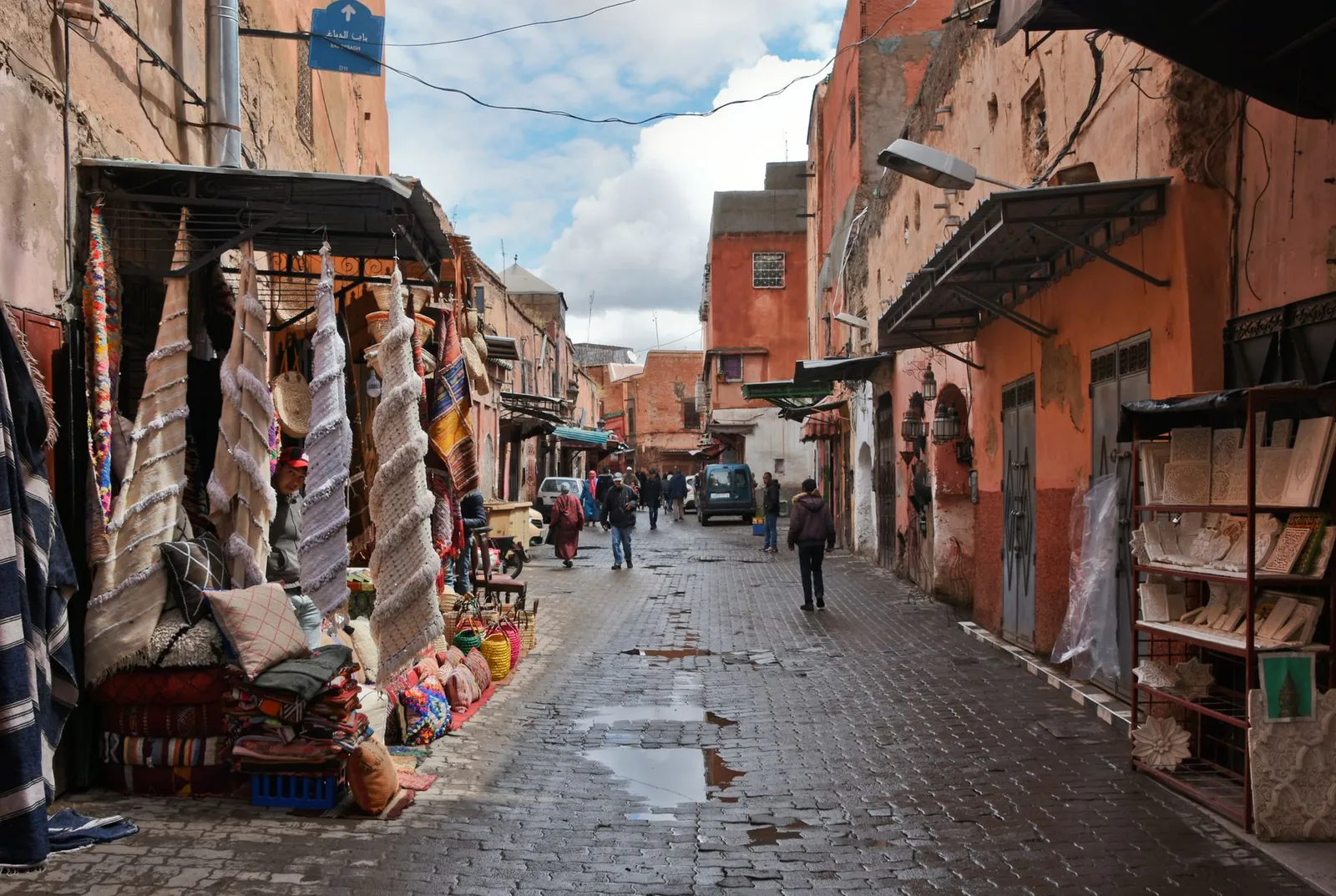 Marrakech: Explore the bustling streets of Marrakech with vibrant fabrics and traditional architecture in this lively market scene.