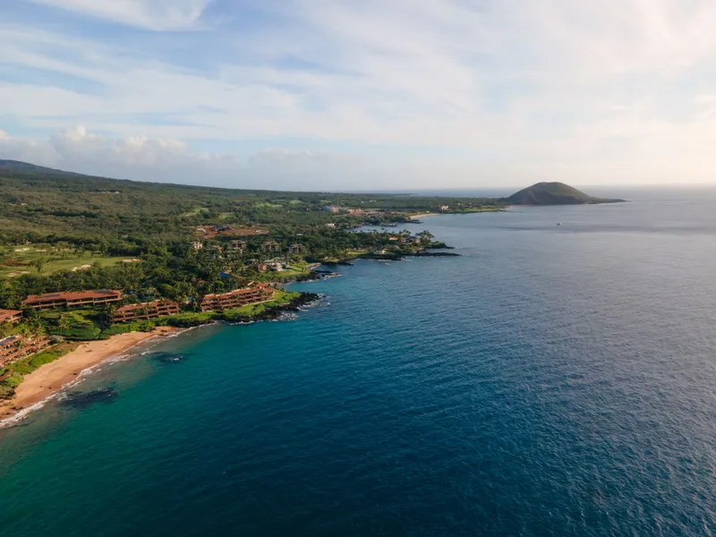 Maui: Stunning aerial view of the lush Wailea-Makena coastline in Maui, Hawaii with clear blue ocean waters.