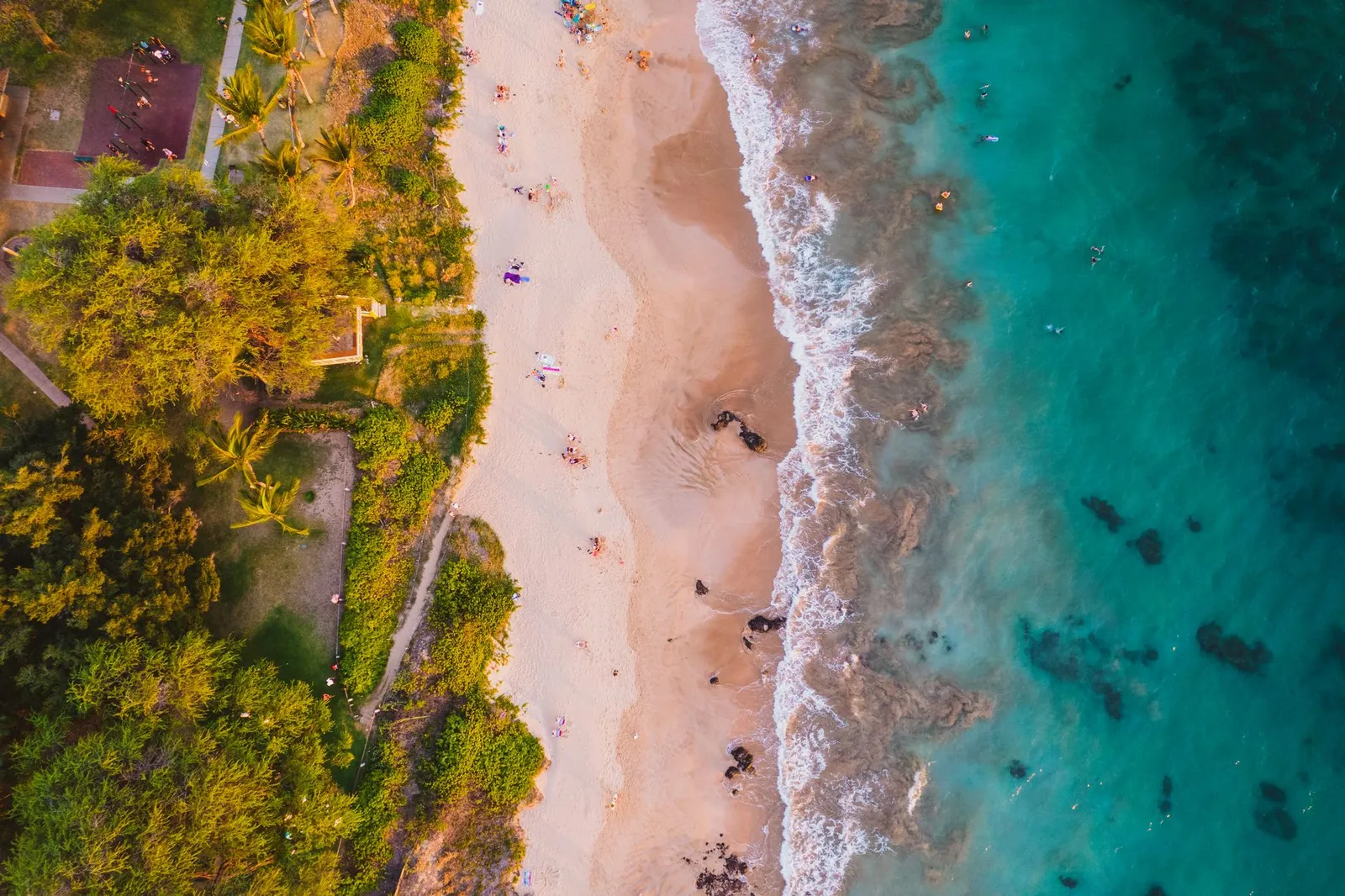 Maui: Stunning aerial view of a tropical beach with turquoise waters and golden sand in Maui, Hawaii.