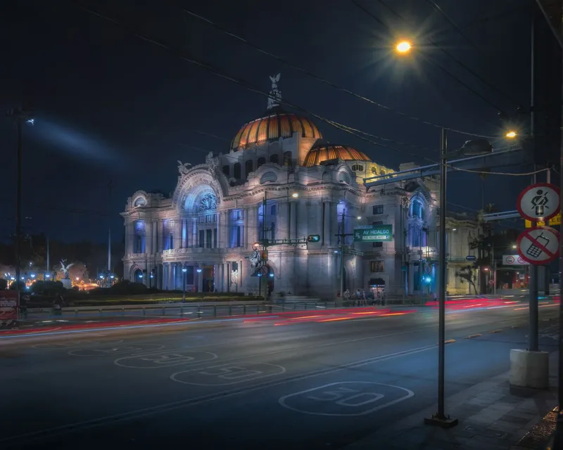Stunning nighttime image of the illuminated Palacio de Bellas Artes, a cultural landmark in Mexico City.