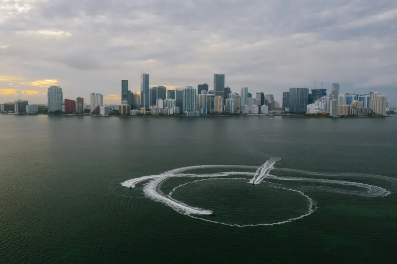 Miami: Aerial shot of Miami's skyline with watercraft patterns on the ocean surface.