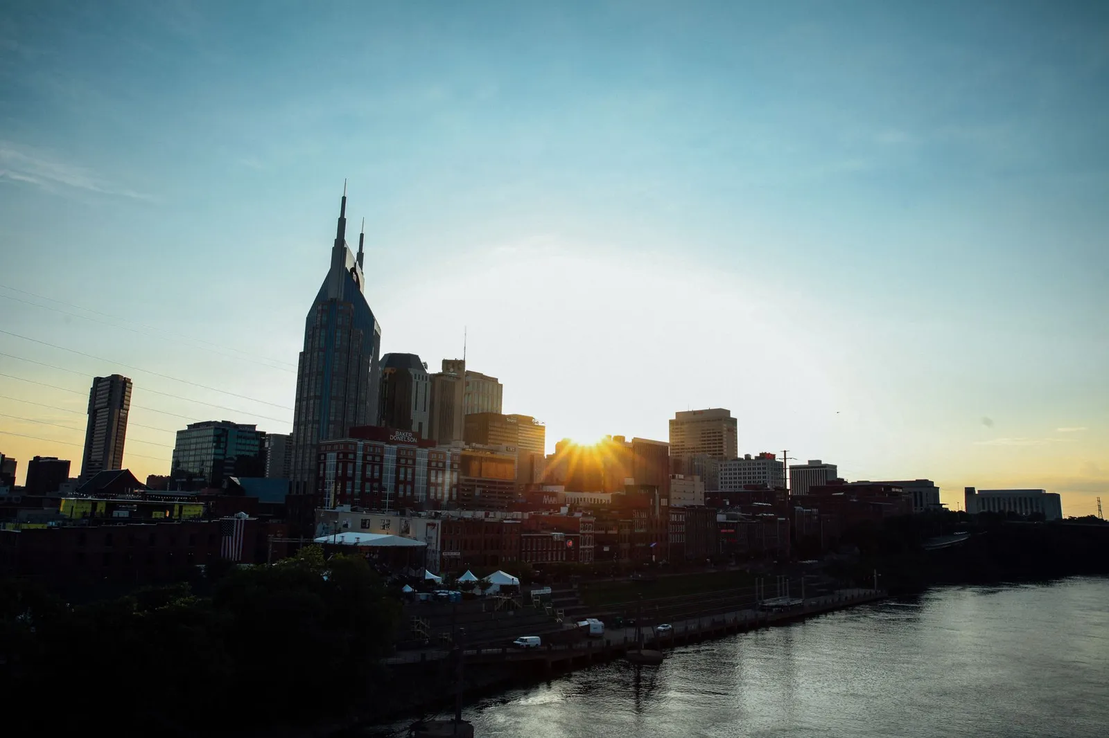Nashville: A stunning view of Nashville's skyline at sunset, featuring a calm waterfront reflection.