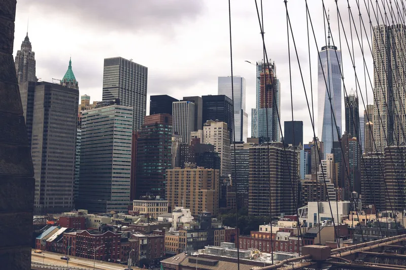 New York City: A dramatic view of the skyscrapers of New York City captured from the Brooklyn Bridge.