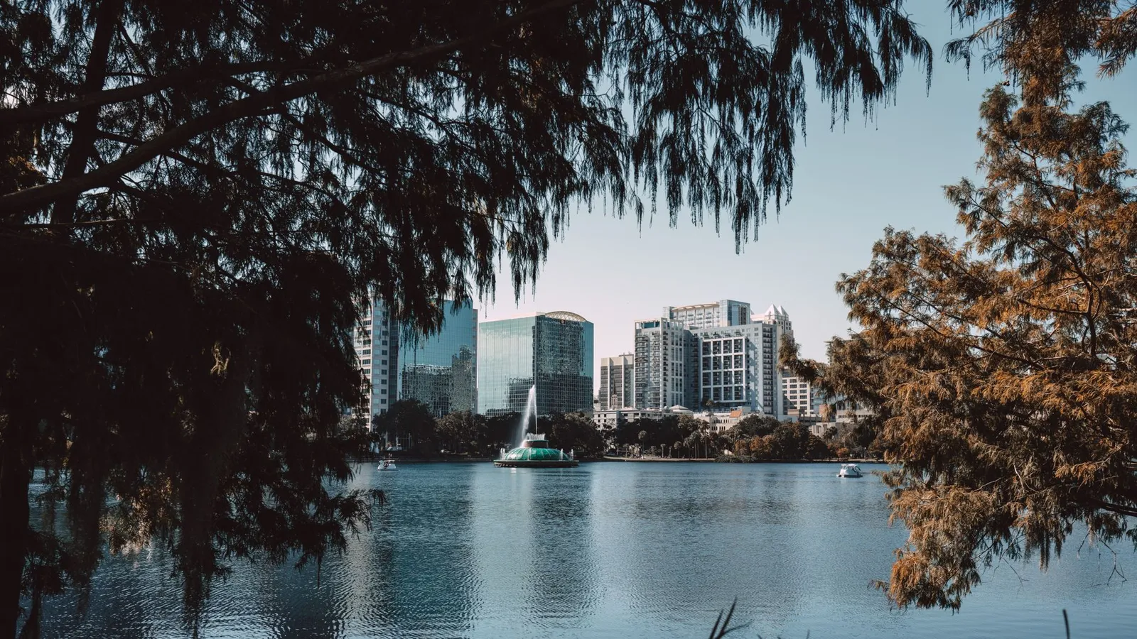 Orlando: Captivating view of downtown Orlando skyline framed by trees at Lake Eola.