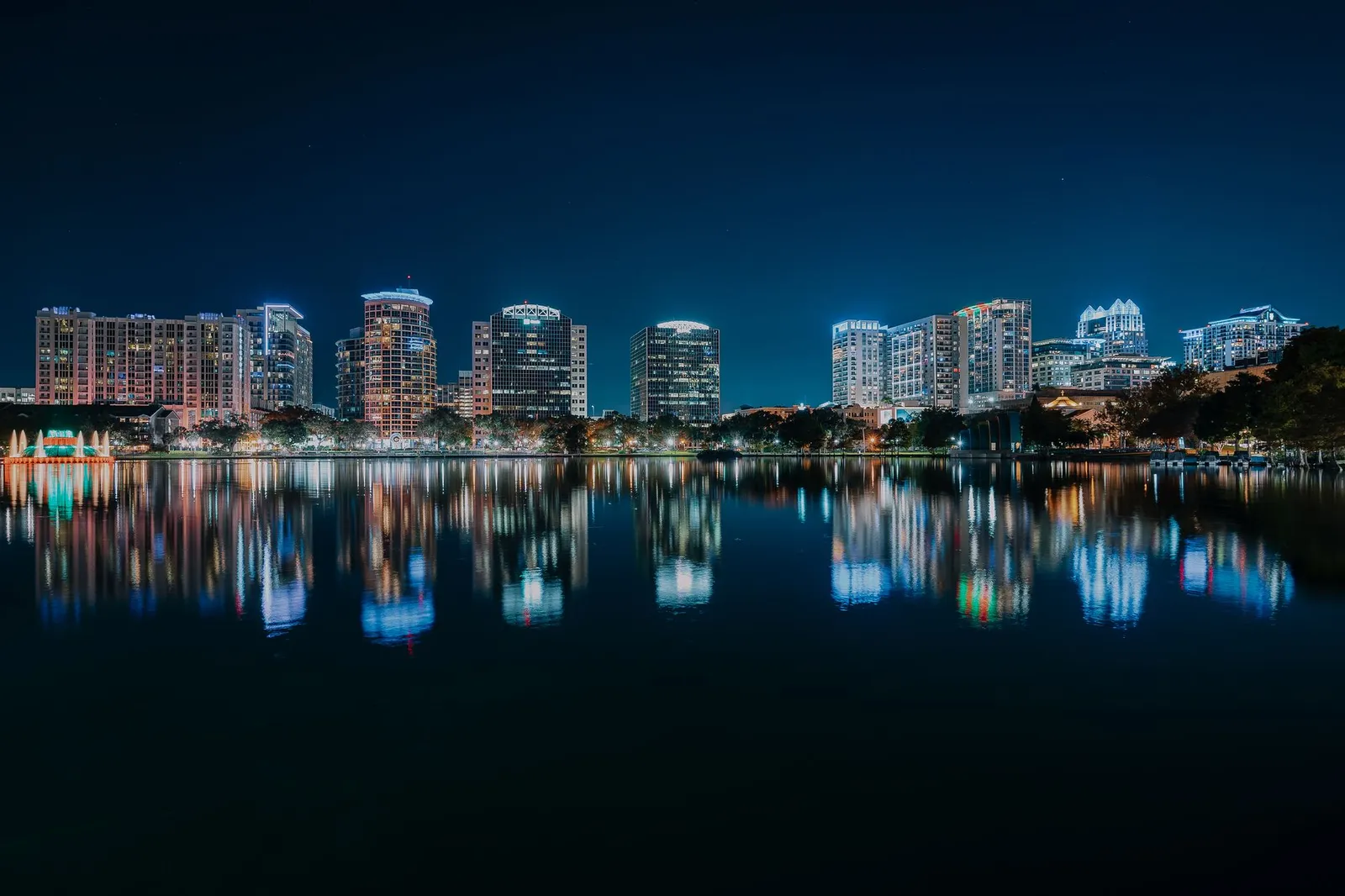 Orlando: Stunning nighttime view of Orlando's illuminated skyline reflecting in a calm body of water.
