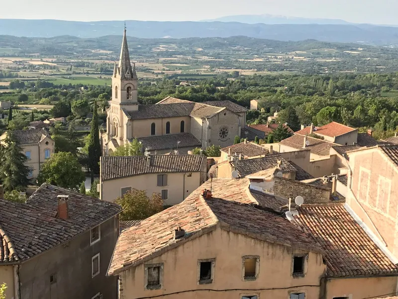 Provence: A picturesque view of Saignon's historic church and surrounding countryside in Provence, France.