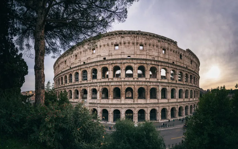 Rome: Captivating wide-angle shot of Rome's iconic Colosseum with a serene sunset backdrop.