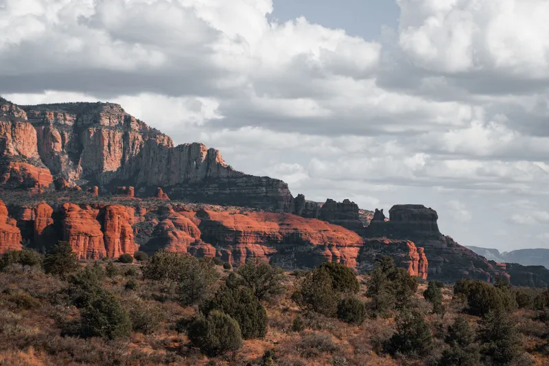 Sedona: Stunning view of Sedona's iconic red rock landscape under a cloudy sky.