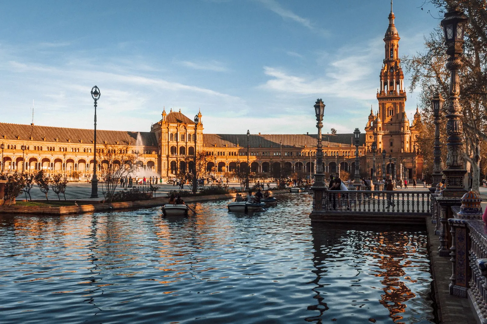 Seville: Scenic view of Plaza de España in Seville with reflections on the canal at sunset.