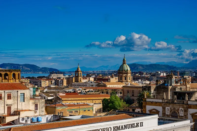 Sicily: Discover the vibrant skyline of Palermo, Sicily capturing historic architecture beneath a bright blue sky.