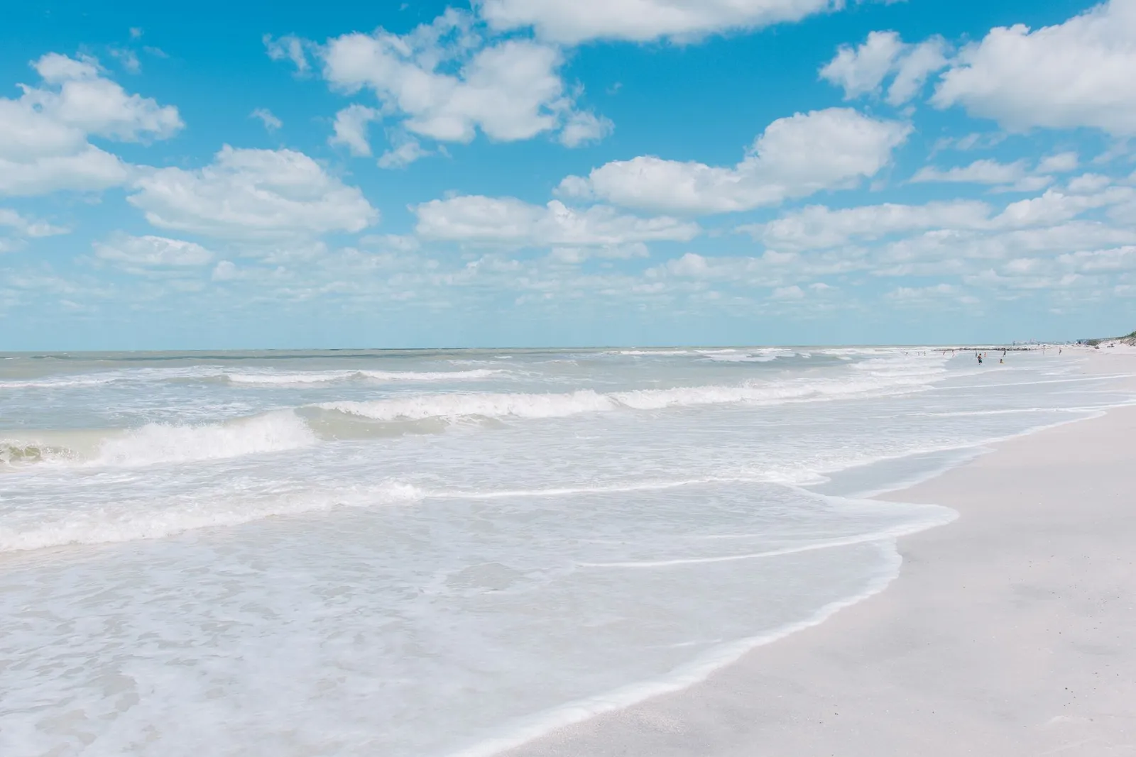 St. Pete / Clearwater: Sunny day at St. Pete Beach, Florida with waves crashing on the shoreline under a clear blue sky.