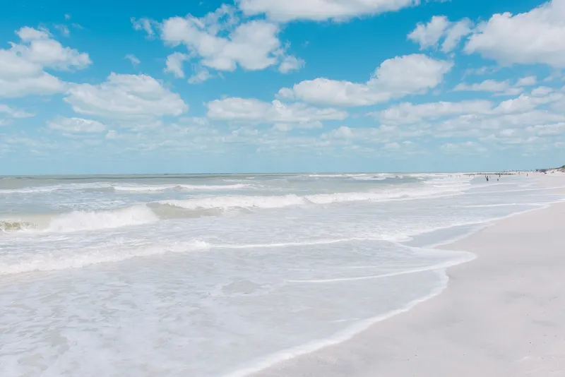St. Pete / Clearwater: Sunny day at St. Pete Beach, Florida with waves crashing on the shoreline under a clear blue sky.