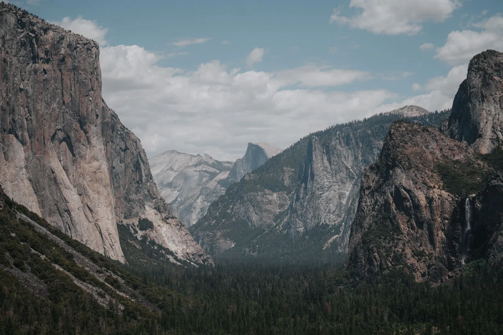 Stunning landscape of Yosemite Valley with El Capitan and lush forest below.